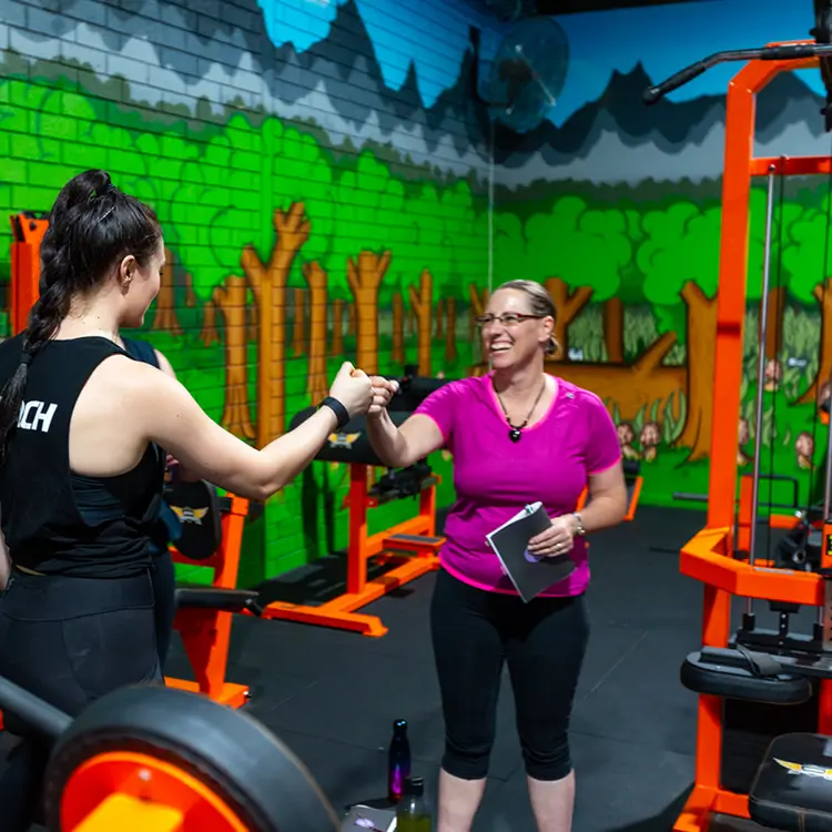 Coach giving one-to-one guidance to a member at Strength and Motion Academy in Midvale